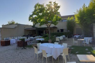 Château gonflable blanc installé sur une surface gravillonnée, entouré de végétation et de mobilier de jardin.