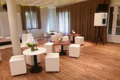 Château gonflable blanc installé sur une surface gravillonnée, entouré de végétation et de mobilier de jardin.