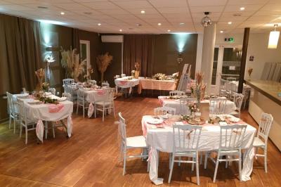 Château gonflable blanc installé sur une surface gravillonnée, entouré de végétation et de mobilier de jardin.