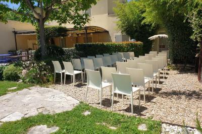 Château gonflable blanc installé sur une surface gravillonnée, entouré de végétation et de mobilier de jardin.
