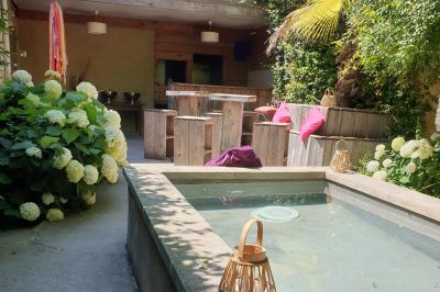 Château gonflable blanc installé sur une surface gravillonnée, entouré de végétation et de mobilier de jardin.