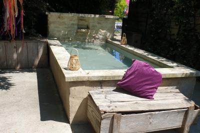 Château gonflable blanc installé sur une surface gravillonnée, entouré de végétation et de mobilier de jardin.