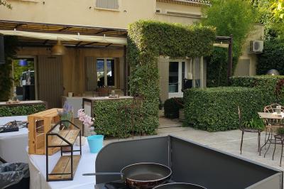 Château gonflable blanc installé sur une surface gravillonnée, entouré de végétation et de mobilier de jardin.