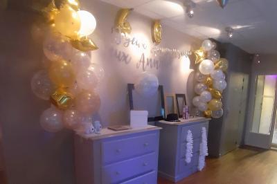 Château gonflable blanc installé sur une surface gravillonnée, entouré de végétation et de mobilier de jardin.