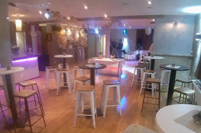 Château gonflable blanc installé sur une surface gravillonnée, entouré de végétation et de mobilier de jardin.