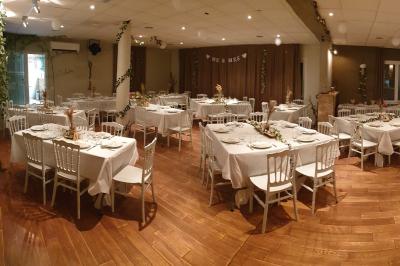 Château gonflable blanc installé sur une surface gravillonnée, entouré de végétation et de mobilier de jardin.