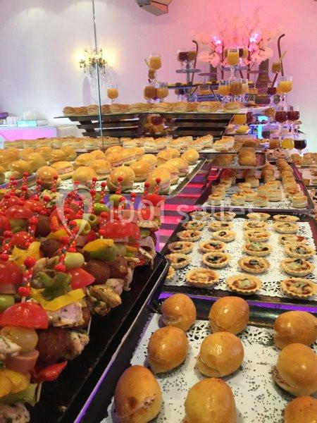 Buffet coloré avec une variété de bouchées salées, brochettes, mini-tartelettes et petits pains.