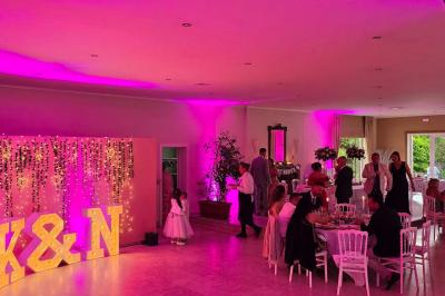 Miniature Location salle Enghien (Hainaut) - La Réserve #16 Lettres lumineuses ’K & N’ blanches posées au sol devant un mur décoré de guirlandes de lierre.