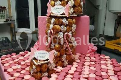 Deux balais déguisés en mariés avec robe et costume, posés devant une tente blanche et un cadre décoratif.