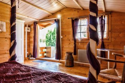 Deux balais déguisés en mariés avec robe et costume, posés devant une tente blanche et un cadre décoratif.