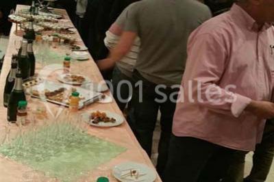 Intérieur d'une tente de réception décorée avec des tables rondes dressées, des chaises blanches et des fleurs.