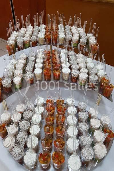 Buffet de verrines variées disposées en arc de cercle, contenant des préparations salées et sucrées avec des cuillères.