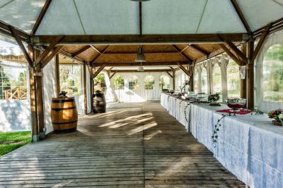Intérieur d'une tente de réception décorée avec des tables rondes dressées, des chaises blanches et des fleurs.