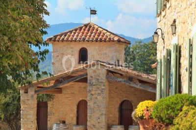 Champ de lavande au premier plan avec des vignes verdoyantes en arrière-plan et des collines à l'horizon.