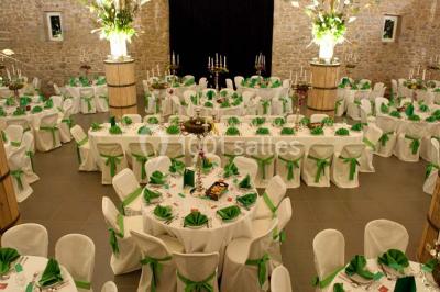 Voûte en briques rouges avec piliers en pierre, sol carrelé gris et mur en pierre apparente.