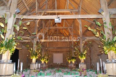 Voûte en briques rouges avec piliers en pierre, sol carrelé gris et mur en pierre apparente.