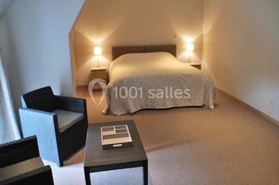 Voûte en briques rouges avec piliers en pierre, sol carrelé gris et mur en pierre apparente.