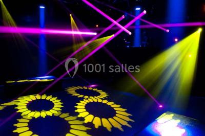 Voûte en briques rouges avec piliers en pierre, sol carrelé gris et mur en pierre apparente.