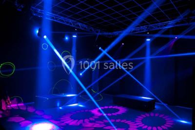 Voûte en briques rouges avec piliers en pierre, sol carrelé gris et mur en pierre apparente.