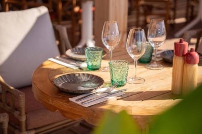 Chambre d'hôtel lumineuse avec lit double, bureau, fauteuil, grandes fenêtres et vue sur un balcon.