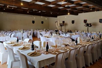 Étang naturel entouré de végétation, avec des chaises longues en arrière-plan et des pierres au premier plan.