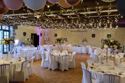 Étang naturel entouré de végétation, avec des chaises longues en arrière-plan et des pierres au premier plan.