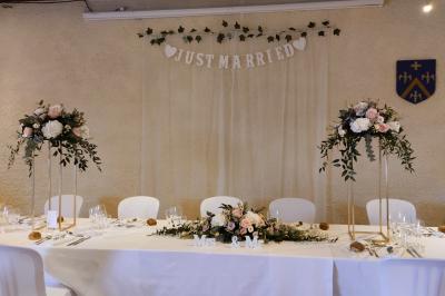 Étang naturel entouré de végétation, avec des chaises longues en arrière-plan et des pierres au premier plan.