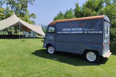 Champ de lotus en fleurs avec des feuilles vertes, des bourgeons et un étang en arrière-plan, entouré d'arbres.