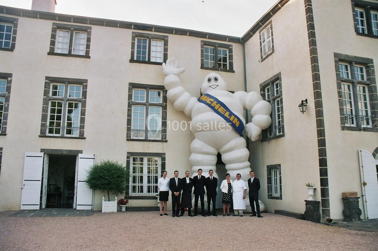 Un groupe de personnes pose devant un grand bâtiment avec une statue gonflable du Bibendum Michelin.