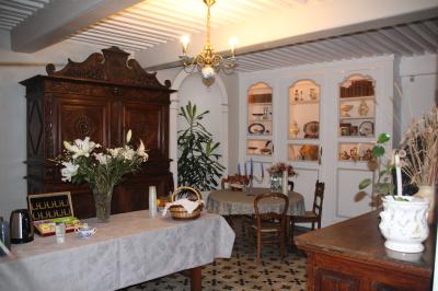 Un groupe de personnes pose devant un tracteur rouge et une machine agricole, devant un grand bâtiment ancien.