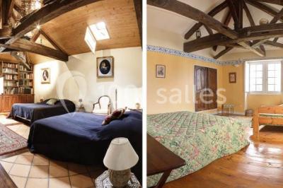 Un groupe de personnes pose devant un tracteur rouge et une machine agricole, devant un grand bâtiment ancien.