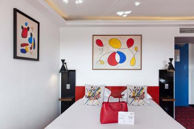 Une femme de dos sur une terrasse, face au Vieux-Port de Marseille, avec une table dressée pour le petit-déjeuner.