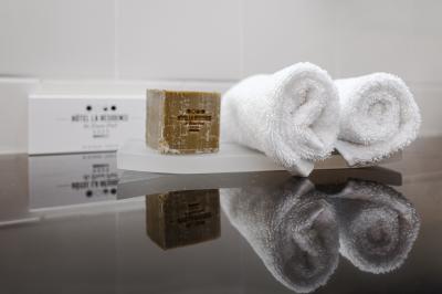 Une femme de dos sur une terrasse, face au Vieux-Port de Marseille, avec une table dressée pour le petit-déjeuner.