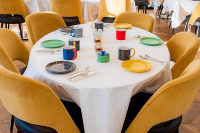 Une femme de dos sur une terrasse, face au Vieux-Port de Marseille, avec une table dressée pour le petit-déjeuner.