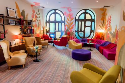 Une femme de dos sur une terrasse, face au Vieux-Port de Marseille, avec une table dressée pour le petit-déjeuner.