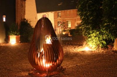 Table de réception décorée avec nappes blanches, serviettes vertes pliées, chaises ornées de nœuds verts et centre de table…