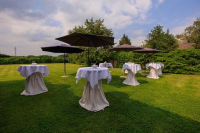 Table de réception décorée avec nappes blanches, serviettes vertes pliées, chaises ornées de nœuds verts et centre de table…