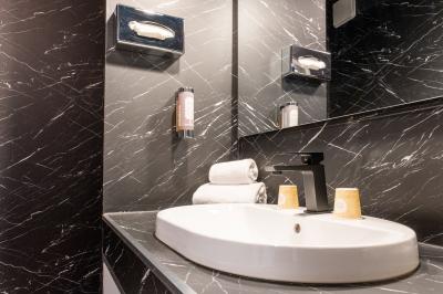 Femme allongée recevant un massage sous une douche d'eau, dans un cadre lumineux et relaxant.