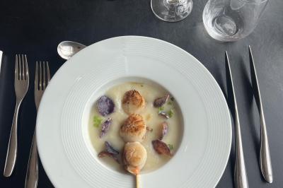 Femme allongée recevant un massage sous une douche d'eau, dans un cadre lumineux et relaxant.
