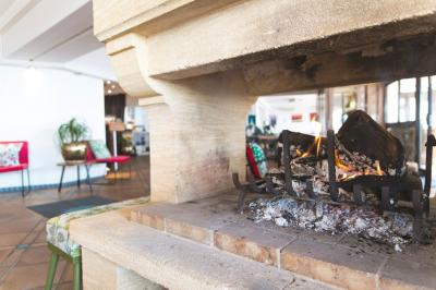 Quatre chevaux blancs galopent sur une plage au bord de l'eau, sous un ciel de coucher de soleil.