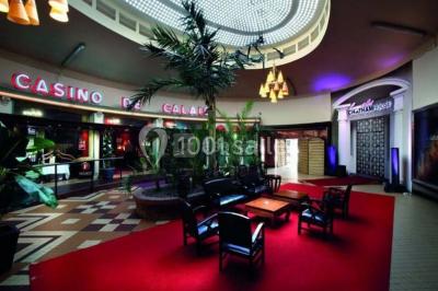 Salle avec un présentoir, des cartons empilés, une table haute décorée et un fond rouge marqué ’50 ans’.