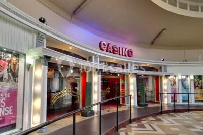 Salle avec un présentoir, des cartons empilés, une table haute décorée et un fond rouge marqué ’50 ans’.