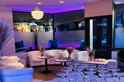 Salle avec un présentoir, des cartons empilés, une table haute décorée et un fond rouge marqué ’50 ans’.