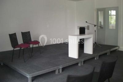 Bureau lumineux avec plusieurs postes de travail équipés de meubles noirs, un ordinateur portable visible au premier plan.