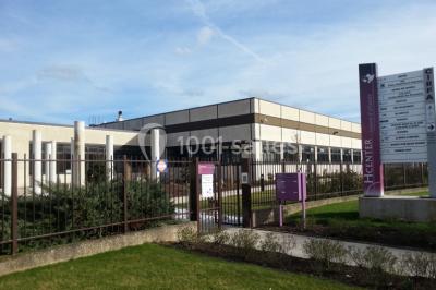 Bureau lumineux avec plusieurs postes de travail équipés de meubles noirs, un ordinateur portable visible au premier plan.