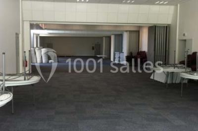 Bureau lumineux avec plusieurs postes de travail équipés de meubles noirs, un ordinateur portable visible au premier plan.