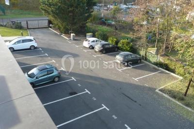 Bureau lumineux avec plusieurs postes de travail équipés de meubles noirs, un ordinateur portable visible au premier plan.