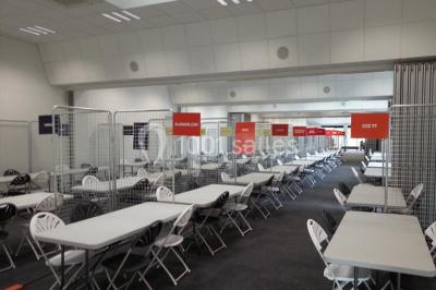 Bureau lumineux avec plusieurs postes de travail équipés de meubles noirs, un ordinateur portable visible au premier plan.