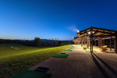 Salle de réception lumineuse avec tables dressées, grandes compositions florales et vue sur une terrasse arborée.