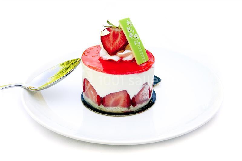 Gâteau individuel à la fraise avec glaçage rouge, crème, fraises fraîches et décoration en chocolat vert sur assiette…